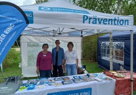 Drei ehrenamtliche Mitarbeiterinnen der Außenstelle Herne an einem Informationsstand des WEISSEN RINGS mit Broschüren und kleinen Giveaways beim Kanalfest im September 2026 in Herne.